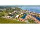 Aerial view shows condo complex with canal access, tennis courts, and lush tropical landscaping at 25188 Marion Ave # D308, Punta Gorda, FL 33950