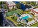 Aerial view of condo complex features a swimming pool, tennis courts, canal, and lush tropical landscaping at 25188 Marion Ave # D308, Punta Gorda, FL 33950