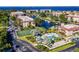 An aerial view showcasing the property's pool, tennis courts, waterfront access, and lush landscaping at 25188 Marion Ave # D308, Punta Gorda, FL 33950
