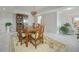 A dining room with a wooden table and chairs, with a china cabinet, bright lighting, and neutral decor at 25188 Marion Ave # D308, Punta Gorda, FL 33950