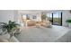 A bright and airy living room with comfortable seating, plants, and a large sliding glass door to the balcony at 25188 Marion Ave # D308, Punta Gorda, FL 33950