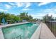 Community pool surrounded by lounge chairs and lush landscaping at 25188 Marion Ave # D308, Punta Gorda, FL 33950