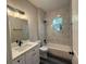 Bathroom featuring a tub-shower combo with tiled wall surround, and vanity with solid surface counter at 302 Albatross Rd, Rotonda West, FL 33947