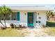 Close up of the home's entryway, highlighting the colorful front door and landscaping at 350 W Cowles St, Englewood, FL 34223