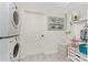 Functional laundry area with a stacked washer and dryer, storage, and beach-themed decor at 350 W Cowles St, Englewood, FL 34223