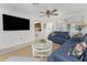 Comfortable living room featuring a blue sofa, ceiling fan, and a glimpse into the bright kitchen at 350 W Cowles St, Englewood, FL 34223