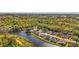 Aerial view of a home with a lake view, surrounded by trees and lush greenery at 410 Blue Springs Ct # 189, Englewood, FL 34223
