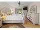 Bright bedroom with wood floors featuring a ceiling fan and a view of the yard at 410 Blue Springs Ct # 189, Englewood, FL 34223