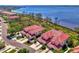 An aerial view of condos near the water with red tile roofs surrounded by palm trees and lush landscaping at 4692 Club Dr # 101, Port Charlotte, FL 33953