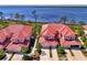 Aerial view of condos featuring red tile roofs and well maintained landscaping near the water at 4692 Club Dr # 101, Port Charlotte, FL 33953