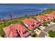 Aerial view of red tiled roof condos near the water showing the lush landscaping and ample parking space at 4692 Club Dr # 101, Port Charlotte, FL 33953
