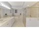 Well-lit bathroom with double sinks, tub, and separate shower at 4692 Club Dr # 101, Port Charlotte, FL 33953