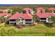 Beautiful exterior of a condo featuring a red tile roof, well-maintained landscaping and screened-in balconies at 4692 Club Dr # 101, Port Charlotte, FL 33953