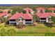 Beautiful exterior of a condo featuring a red tile roof, well-maintained landscaping and screened-in balconies at 4692 Club Dr # 101, Port Charlotte, FL 33953