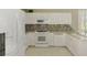 Modern kitchen with white cabinets, granite counters, and stainless appliances at 4692 Club Dr # 101, Port Charlotte, FL 33953