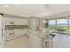 Bright modern kitchen featuring white cabinets, island, and water views at 4692 Club Dr # 101, Port Charlotte, FL 33953