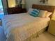 Bedroom featuring a woven headboard, dresser, and ample natural light at 5 Quails Run Blvd # 9, Englewood, FL 34223