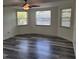 Bedroom features three windows for natural light and a modern ceiling fan above the gray flooring at 5234 Forbes Ter, Port Charlotte, FL 33981