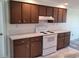 The kitchen offers white appliances, wood cabinets, and ample counter space at 5234 Forbes Ter, Port Charlotte, FL 33981