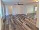 Spacious living area featuring gray wood-look flooring, neutral paint, and open access to other rooms at 5234 Forbes Ter, Port Charlotte, FL 33981