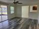 View of living room with wood-look flooring, leading to the lanai and kitchen at 5234 Forbes Ter, Port Charlotte, FL 33981