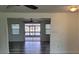 Open living room features gray wood-look flooring, access to lanai, and a ceiling fan at 5234 Forbes Ter, Port Charlotte, FL 33981