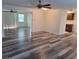 Open living area featuring freshly painted walls, ceiling fans, and modern wood-look flooring at 5234 Forbes Ter, Port Charlotte, FL 33981