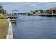 Picturesque waterfront view showcasing docks, boats, and waterfront homes under a partly cloudy sky at 5234 Forbes Ter, Port Charlotte, FL 33981