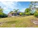 Expansive backyard features a screened lanai, lush green grass and tropical landscaping at 533 Boundary Blvd, Rotonda West, FL 33947