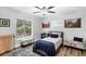 Charming bedroom with a ceiling fan, two windows, wood floors, and desert-themed artwork at 533 Boundary Blvd, Rotonda West, FL 33947
