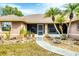 Welcoming front entrance with a paved walkway, potted plants, and charming palm trees, creating curb appeal at 533 Boundary Blvd, Rotonda West, FL 33947
