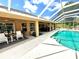 Inviting screened pool area with comfortable seating and a ceiling fan for outdoor relaxation at 533 Boundary Blvd, Rotonda West, FL 33947