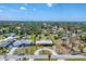 Wide aerial shot of a quiet neighborhood showcasing lush tree canopy with the home in the center at 551 Morrison Ave, Englewood, FL 34223