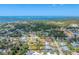 Expansive aerial shot showcasing a residential neighborhood with mature trees and homes, near the tranquil ocean at 551 Morrison Ave, Englewood, FL 34223