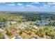 Aerial shot shows the property's location, surrounded by a mix of residential homes, trees, and a picturesque pond at 551 Morrison Ave, Englewood, FL 34223
