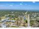 Expansive aerial view of the neighborhood showcasing mature trees and a glimpse of the coastal waterway at 551 Morrison Ave, Englewood, FL 34223