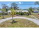 Charming exterior view of the home shows curb appeal with a circular driveway and lush landscaping at 551 Morrison Ave, Englewood, FL 34223