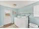 Bright laundry room with a washer and dryer, shelving and access to the backyard at 551 Morrison Ave, Englewood, FL 34223