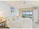 Light and airy bedroom features a ceiling fan and sliding glass doors to a waterfront balcony at 5856 Gasparilla Rd # Mv26, Boca Grande, FL 33921