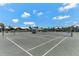 Well-maintained tennis court with a green playing surface, set against a backdrop of lush landscaping and blue skies at 5856 Gasparilla Rd # Mv26, Boca Grande, FL 33921