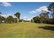 Expansive backyard featuring mature trees and lush green lawn at 60 N Oxford Dr, Englewood, FL 34223