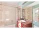 Bathroom showcasing a bathtub, vanity, neutral tile work and ample natural light at 60 N Oxford Dr, Englewood, FL 34223