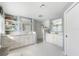 Bright bathroom featuring double vanity, marble countertops, white cabinets, and walk-in shower at 60 N Oxford Dr, Englewood, FL 34223