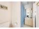 Cozy bathroom featuring a single vanity, framed art, and a blue floral shower curtain at 60 N Oxford Dr, Englewood, FL 34223