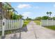 Long driveway leading to a pristine property with a well-maintained lawn and lush landscaping at 60 N Oxford Dr, Englewood, FL 34223