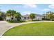 Stunning one-story home boasting lush landscaping, a circular driveway, and a white exterior at 60 N Oxford Dr, Englewood, FL 34223