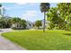 Lush front yard with palm trees, a circular driveway, and a well-maintained lawn for an inviting curb appeal at 60 N Oxford Dr, Englewood, FL 34223