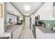 Updated kitchen featuring white cabinets, stainless steel appliances, and a breakfast bar at 60 N Oxford Dr, Englewood, FL 34223