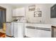 Laundry room featuring a washer, dryer, counter space and ample cabinetry for storage at 60 N Oxford Dr, Englewood, FL 34223