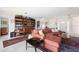 Living room featuring bright lighting, bookshelves and a large area rug at 60 N Oxford Dr, Englewood, FL 34223